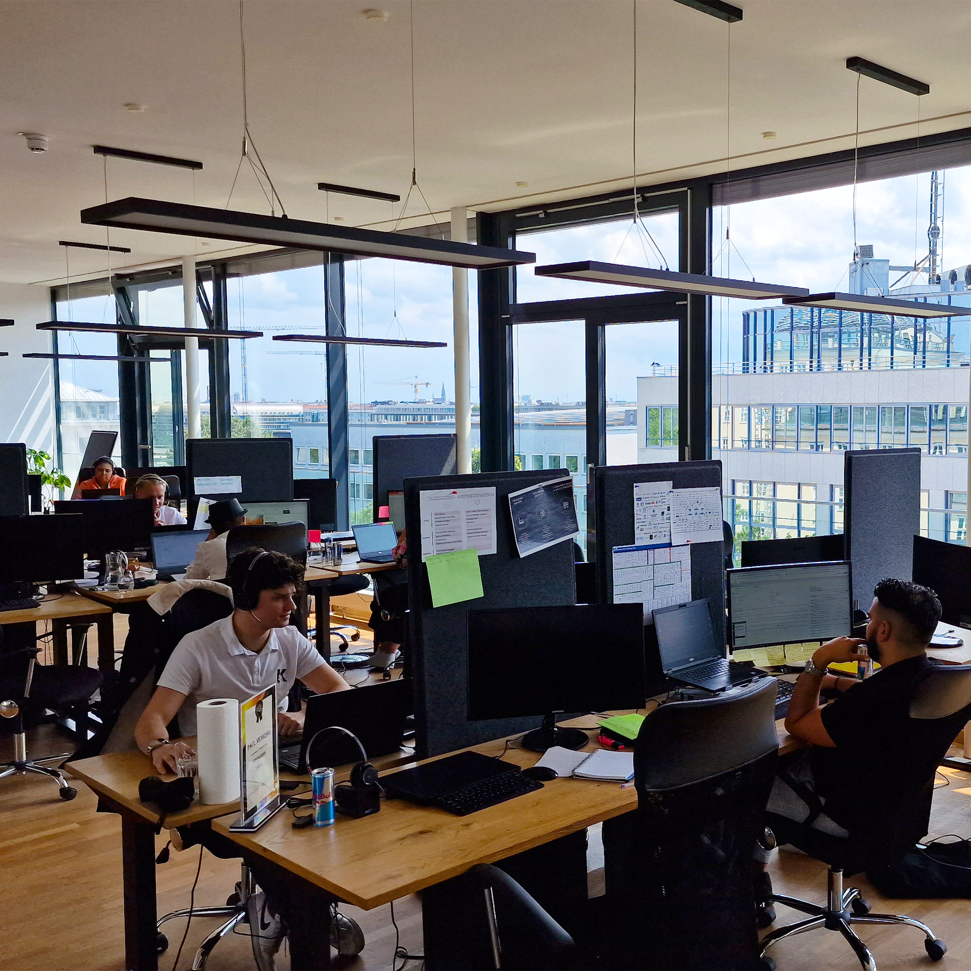 A couple of our employees sitting at their desk in the big office area